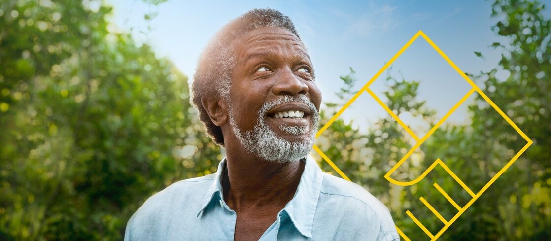 Hombre sonriente con barba delante de unos árboles con un resumen del gráfico de generación de valor para el accionista